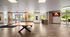 Elegant communal lounge with modern wood flooring, a sleek ping pong table, and a cozy digital fireplace creating an inviting atmosphere.