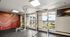 Contemporary apartment gym with vibrant wall art, abundant natural light, and a professional weightlifting station for an energetic workout experience.