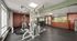 Modern fitness center with state-of-the-art gym equipment, large mirrors, and bright window views for an invigorating workout experience.