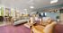 Bright and inviting communal lounge with modern furniture, large windows, and vibrant decor to enhance social gatherings.