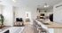 Modern open-concept living space with sleek kitchen and inviting living room, featuring stylish decor and ample natural light.