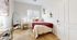 Bright and cozy bedroom featuring a large window, plush carpeting, and modern decor, perfect for relaxation.