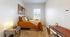 Cozy bedroom with a plush bed, stylish decor, and a sunlit window, perfect for relaxation and comfort.