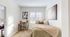 Cozy bedroom with plush bedding, stylish desk, and large window offering natural light.