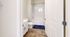 Bright contemporary bathroom with elegant fixtures, featuring a pristine bathtub and stylish vanity, offering a refreshing and modern ambiance.