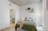 Modern bedroom with stylish green bedding, trendy decor, and an ensuite bathroom offering comfort and elegance.