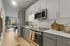 Modern kitchen with sleek cabinetry, stainless steel appliances, and a cozy dining area overlooking city views.