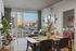 Chic urban apartment with modern decor featuring a cozy dining area, inviting living space with city views, and a glimpse into a stylish bedroom.