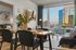 Chic urban apartment with modern dining area, cozy living room, and a stunning city view from the window.