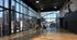 Luxurious indoor basketball court with stunning city skyline views through floor-to-ceiling windows, featuring two players engaging in an exciting game.