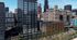 Modern high-rise apartment building with sleek glass facade in vibrant urban cityscape, surrounded by iconic architecture.