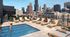 Elegant rooftop pool scene with sun loungers and city skyline backdrop, offering a luxurious urban oasis for relaxation and socializing.