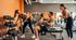 Vibrant gym scene with people enjoying a workout, showcasing a modern fitness facility with ample equipment and a welcoming atmosphere.