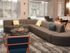 Resident lounge at our New Brunswick student apartments, featuring long couches, chairs, and carpeted flooring.