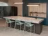 Resident lounge at our New Brunswick student apartments, featuring long couches, chairs, and carpeted flooring.