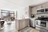 Bright and modern open-plan kitchen and living area with stainless steel appliances and large windows offering stunning city views.