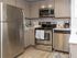 Modern kitchen with stainless steel appliances, sleek cabinetry, and stylish wood flooring.