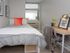 Cozy bedroom with modern decor, featuring a comfortable bed, stylish desk, and a large window inviting natural light.
