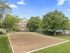 Charming outdoor sand volleyball court surrounded by lush greenery in a vibrant apartment community.