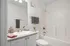 Chic modern bathroom featuring a sleek countertop, elegant sink, and cozy bathtub with refined decor.