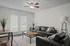 Chic and modern living room with sleek black leather sofas, stylish wooden tables, and natural light from double doors, creating a welcoming ambiance.
