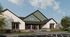 Exterior rendering of a modern farmhouse-style community clubhouse with white and green board-and-batten siding, brick accents, landscaped flower beds, and a covered entrance.