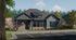 Single-story blue-gray cottage-style rental home with brick wainscoting, covered front porch, black trim, and landscaped surroundings.