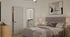 Primary bedroom with upholstered bed, vaulted ceiling, soft neutral finishes, walk-in closet access, and ensuite bathroom entry.