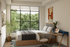 Bright and cozy bedroom with modern decor, featuring a large window with lush green views, a stylish desk, and inviting bed.
