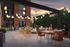 Charming rooftop patio with soft lighting, colorful seating, and lush greenery, perfect for socializing at sunset.
