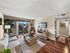 Apartment living room with wood-style flooring, sliding glass door, and private patio access.