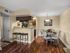 Apartment dining area with breakfast bar seating, wood-style flooring, and open kitchen layout.