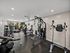 Apartment community fitness center with strength training machines, free weights, and workout benches