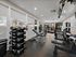 Apartment community fitness center with free weights, strength machines, and workout bench