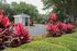 Gated Apartment Community Entrance with Lush Landscaping and Tree-Lined Drive