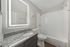 Updated apartment bathroom with granite countertop vanity and bathtub shower