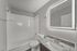 Two-bedroom apartment bathroom with granite countertop vanity, LED mirror, and tub-shower combination