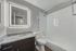 One-bedroom apartment bathroom with granite vanity, LED mirror, and tub-shower combination