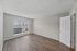 Two-bedroom apartment guest bedroom with large window and wood-style flooring