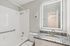 Apartment bathroom featuring granite vanity countertop, modern lighted mirror, and tub-shower combination.