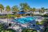 Resort-style swimming pool at Vetra West Apartments in Orlando Florida with lounge seating and palm trees