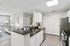 Clubhouse kitchen with bar seating, dining tables, and modern finishes