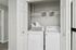 Apartment laundry closet with washer, dryer, and storage shelf