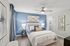 Bedroom with ceiling fan, wood-style flooring, and walk-in closet