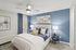Bedroom with ceiling fan, wood-style flooring, and walk-in closet