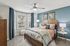 Bedroom with ceiling fan, large windows, wood-style flooring, and modern furnishings