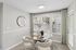 Dining area with round glass table, upholstered chairs, and large windows