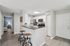 Modern kitchen with breakfast bar seating, white cabinets, and stainless steel appliances