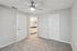 Bedroom with carpet flooring, ceiling fan, double doors, and direct access to bathroom vanity area