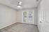 Empty bedroom with ceiling fan, carpet flooring, and sliding door access to outdoor patio